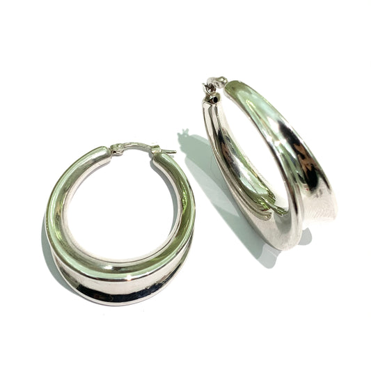 Orecchini in argento ovali lisci con bordi sporgente. Lunghezza totale 3,5 cm, di cui diametro interno 2,5 cm. Larghezza totale 2,5 cm, di cui 2 cm diametro interno. Spessore orecchini 1 cm nella parte inferiore più largo e 0,5 cm nei lati. Chiusura a baionetta. Spedizione gratuita con confezione regalo.