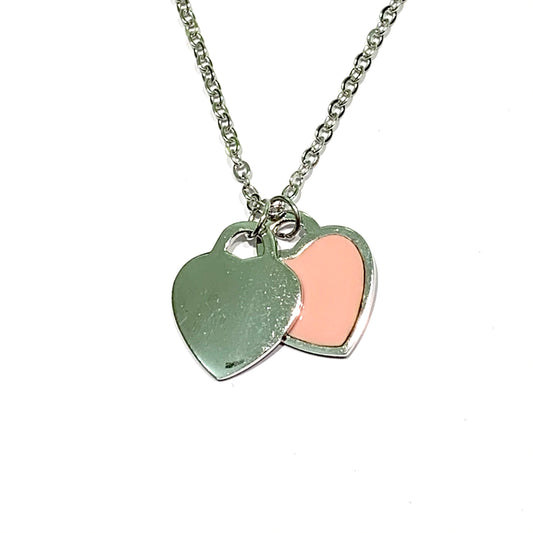 Collana in argento con due cuori pendenti di cui uno in argento e uno smaltato. Lunghezza catena 40 cm regolabile fino a 45 cm. Dimensioni cuore 2 cm. Disponibile nel colore rosa e verde acqua. Spedizione gratuita con confezione regalo.