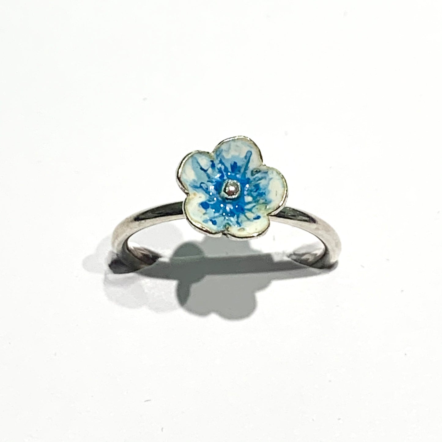 Anello in argento con fiore ricoperto da smalto naturale azzurro.  Dimensioni fiore 0,8 cm.  Misura regolabile da 13 a 15. 