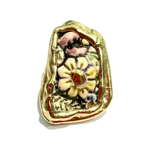 Anello in bijoux bagnato in oro giallo con fiori smaltati sulla piastra. Misura regolabile da 13 a 16. Dimensioni piastra 4,5 cm di lunghezza, 3,5 cm di larghezza nella parte più larga.