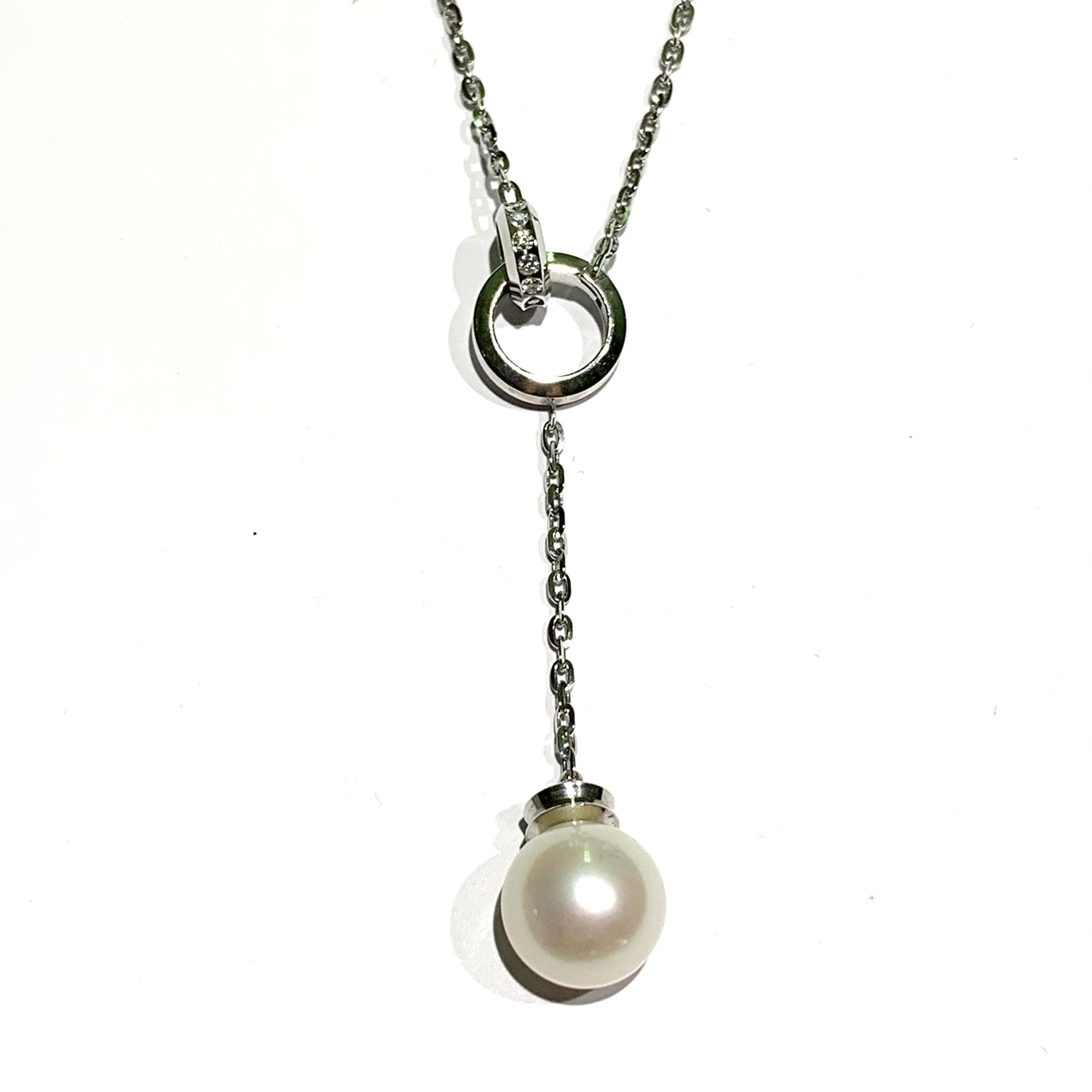 Collana in oro bianco 18kt con cerchietti con diamanti e perla coltivata pendente.  Lunghezza catena 44 cm.  Lunghezza ciondolo pendente 5,5 cm.  Dimensioni perla 1 cm.  Spedizione gratuita con confezione regalo. 