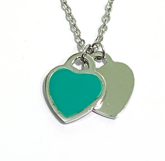 Collana in argento con due cuori pendenti di cui uno in argento e uno smaltato. Lunghezza catena 40 cm regolabile fino a 45 cm. Dimensioni cuore 2 cm. Disponibile nel colore rosa e verde acqua. Spedizione gratuita con confezione regalo.