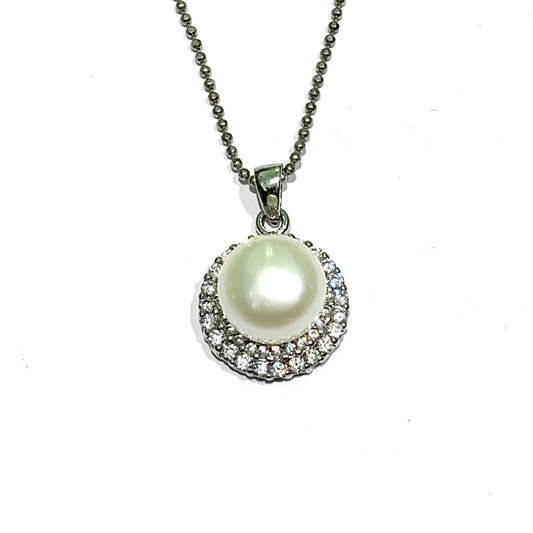 Collana in argento con una piastrina tonda ricoperta da una perla coltivata centrale e da due giri di zirconi. Lunghezza catena 40 cm. Dimensioni ciondolo 1,5 cm di larghezza e 0,5 cm di spessore. Spedizione gratuita con confezione regalo.