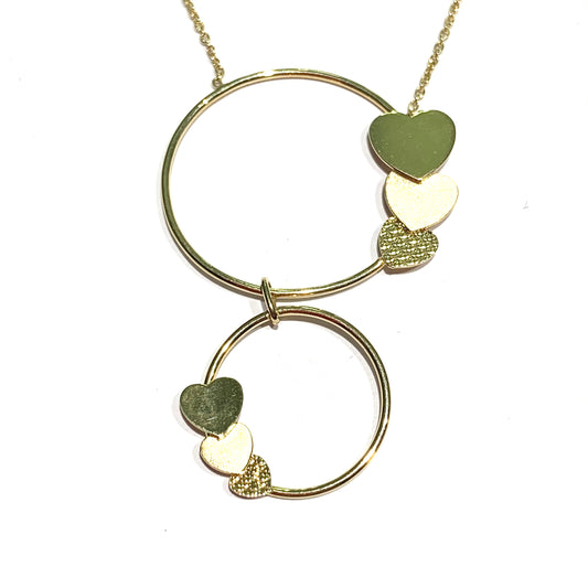 Collana in oro giallo 9kt con due cerchi e cuori lucidi e satinati. Lunghezza catena regolabile in due lunghezze a 38 cm oppure a 42 cm. Lunghezza totale ciondolo 4 cm, di cui il cerchio più grande 2,5 cm e il cerchio più piccolo 1,5 cm. Spedizione gratuita con confezione regalo.