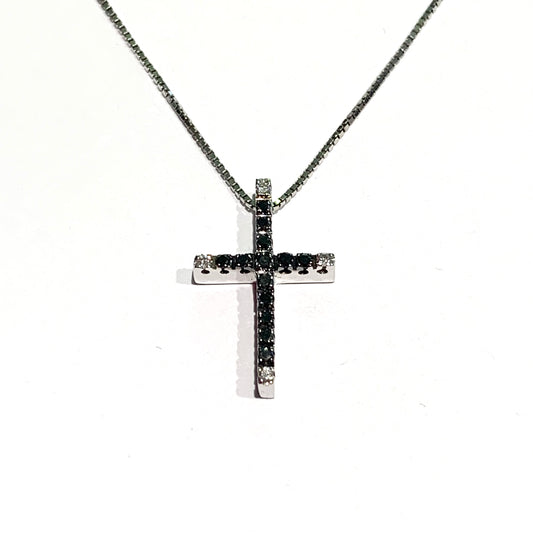 Collana in oro bianco 18kt con croce ricoperta da diamanti neri, e quattro diamanti bianchi nelle punte. Caratura diamanti 0,10. Lunghezza catena 42 cm. Dimensioni croce 2,8x1 cm. Spedizione gratuita con confezione regalo.