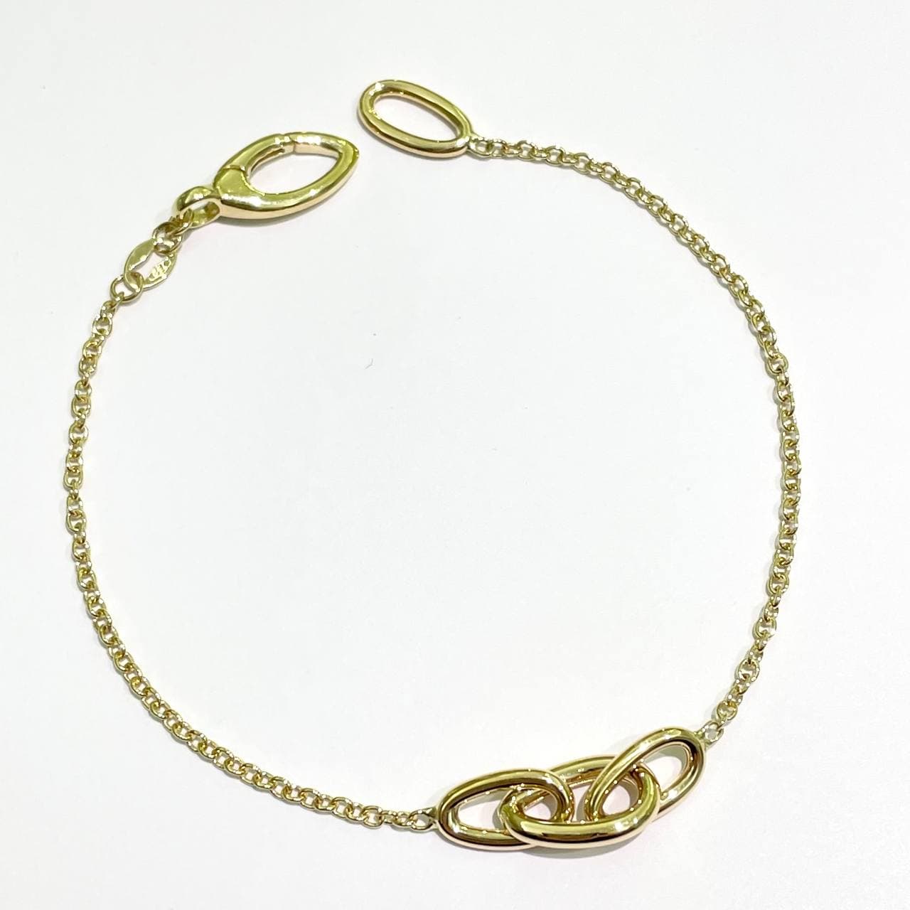 Bracciale in oro giallo 18ktcon tre anelli intrecciati nella parte centrale. Lunghezza 18,5 cm.  Larghezza anelli 0,5 cm.