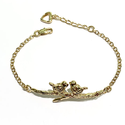 Bracciale in bronzo bagnato nell'oro 24kt trattato con cataforesi per garantirne la brillantezza nel tempo, impreziosito da una coppia di soggetti appoggiata su un rametto. Disponibile con la coppia di uccellini oppure con le lumache. Lunghezza regolabile da 18 cm a 21 cm. Lunghezza rametto 5 cm. Altezza lumachine/uccellini 1 cm. Spedizione gratuita con confezione regalo.