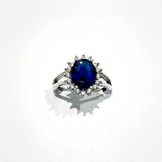 Anello in argento con zircone ovale colore zaffiro circondato da zirconi bianchi. Disponibili in due grandezze: Zaffiro piccolo 0,6 cm, misura anello 14. Zaffiro grande di 0,8 cm, misura anello 12.